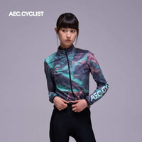 Women's WINTER thermal Jersey with long sleeves in blue-purple tie-dye pattern, high collar, and front zipper closure with logo on sleeve.
